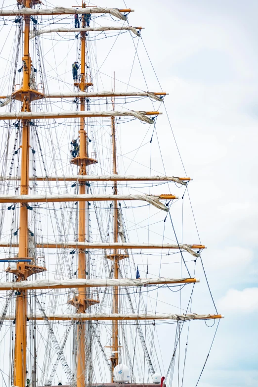 a large yellow ship sailing next to other boats