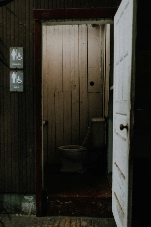 an open doorway showing a toilet and two doors