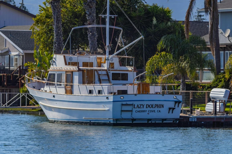 a boat sits docked near a large house