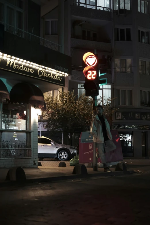 a person carrying bags under a neon sign in a city