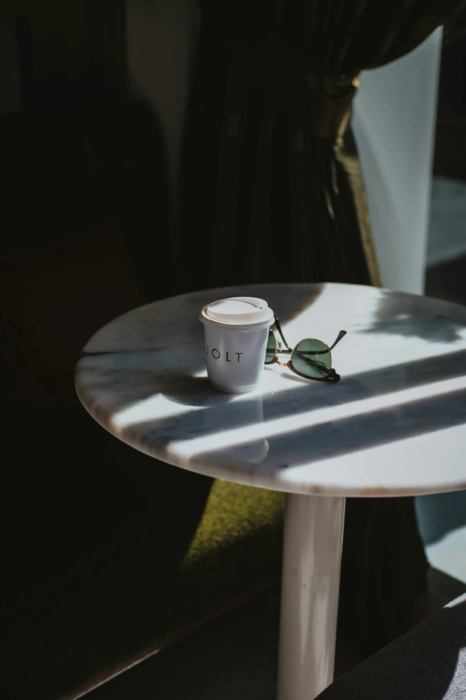 a white table with a single coffee cup on it