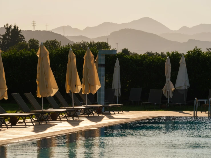 a long swimming pool with umbrellas sitting on the edge