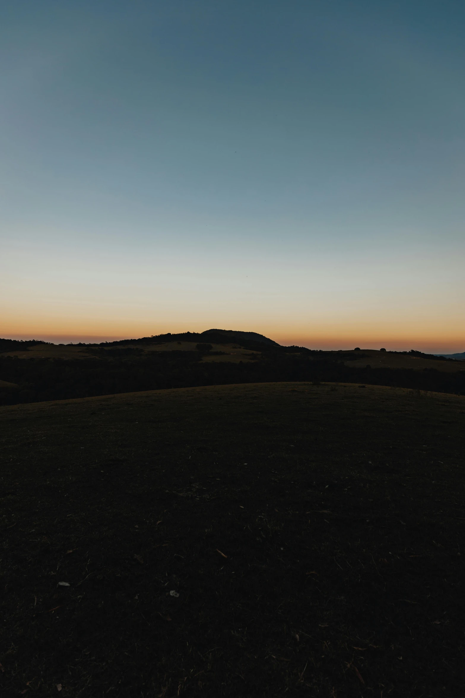 silhouettes of hills in the horizon at dusk