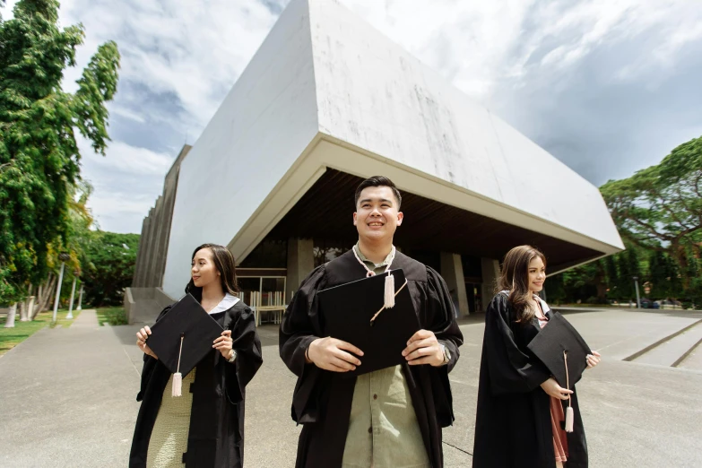 three young men are dressed in black robes with robes on