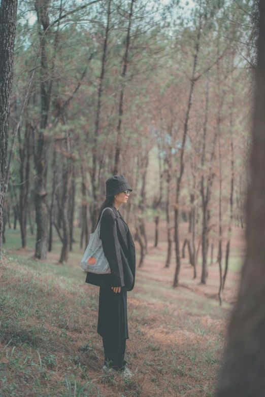 woman in black outfit standing in forest area