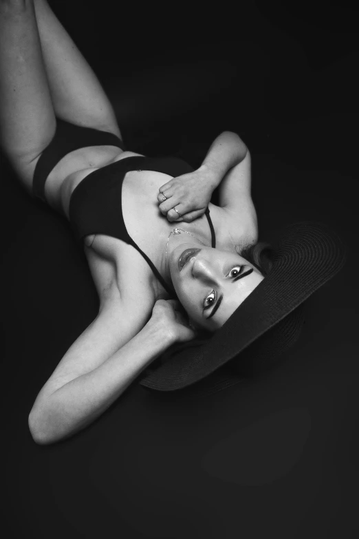 a black and white pograph of a woman laying down wearing stockings