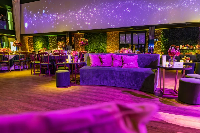 this is a modern setting with purple seating and large screens