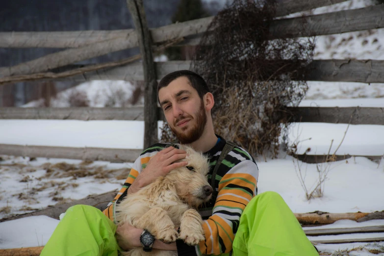 a young man holding a furry white dog in his lap