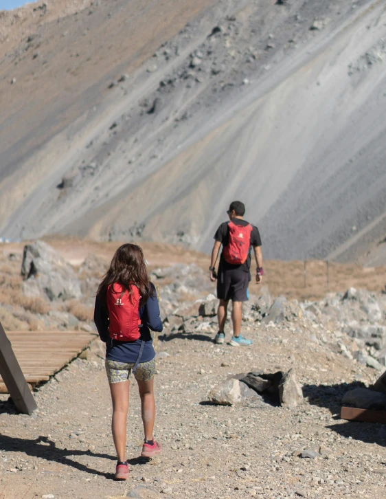 a man and a woman hiking up a hill