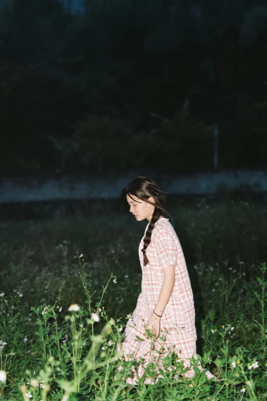 a woman in a field walking at night