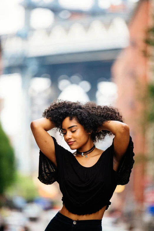 woman with her hands behind her head posing in the rain