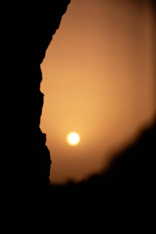 the silhouette of a rock wall is shown in the sunset