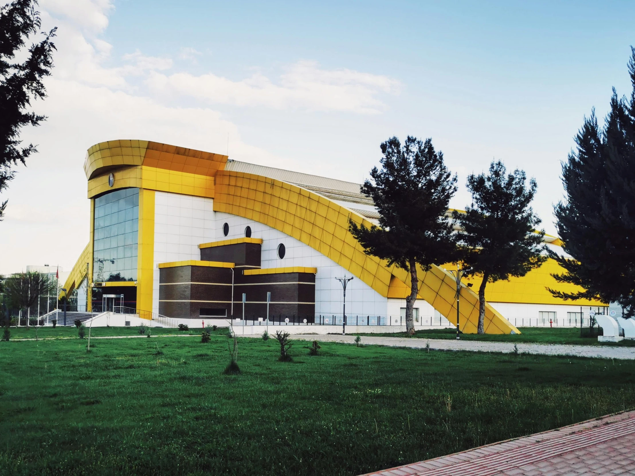 a large yellow and white building with trees in front of it