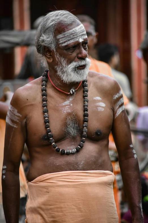 a man in a traditional indian garb with beaded necklace