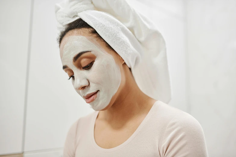 a woman putting on a facial mask