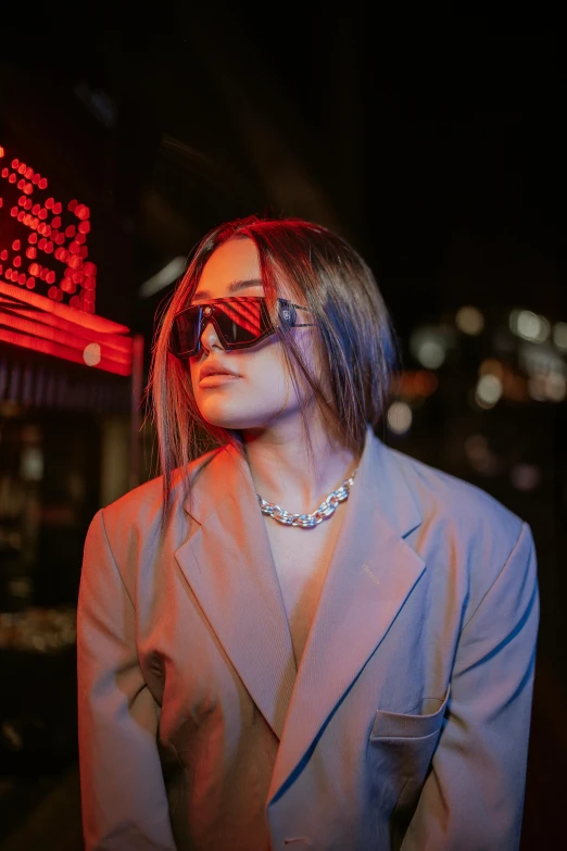 a woman standing in front of a neon sign