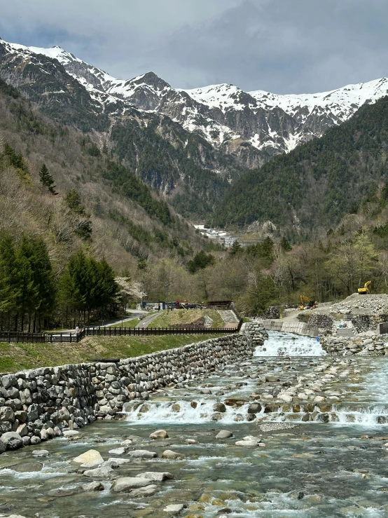 a river runs through a valley past a mountain range