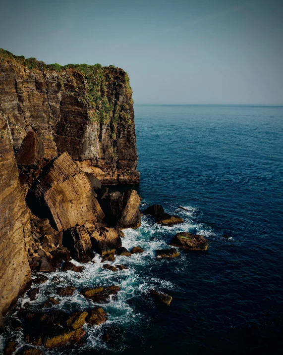 large cliffs sticking out of the middle of a cliff in water