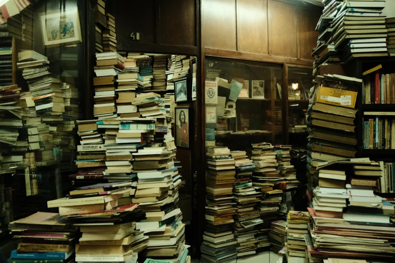 a stack of books sitting on top of an open book case