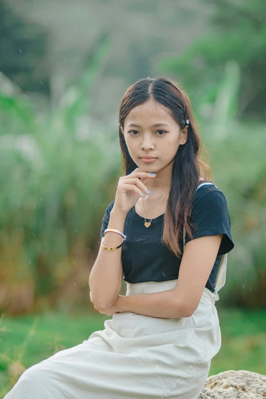 an asian woman poses in the grass for a portrait