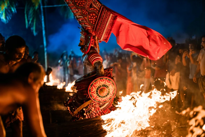 a group of people standing around an open fire