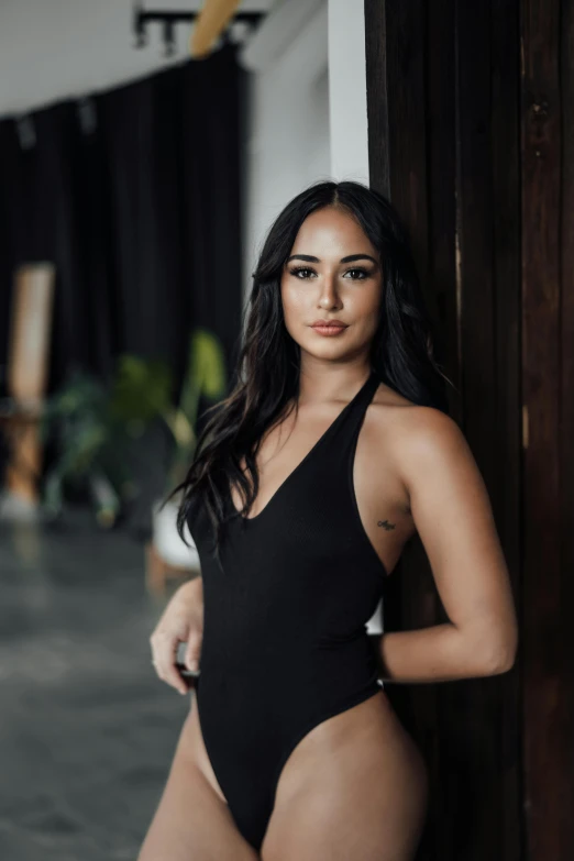 a beautiful young woman posing in black swimsuit