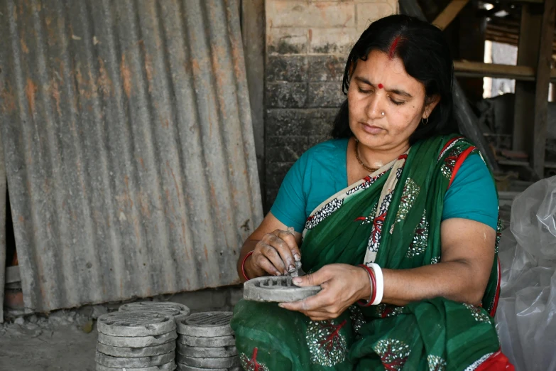 a woman sewing in a rural indian village