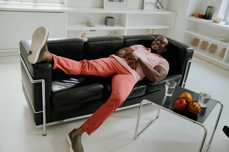 a man with his head propped on the back of a black couch