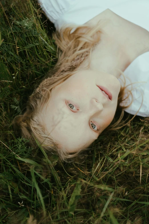 a young child is laying down on the grass