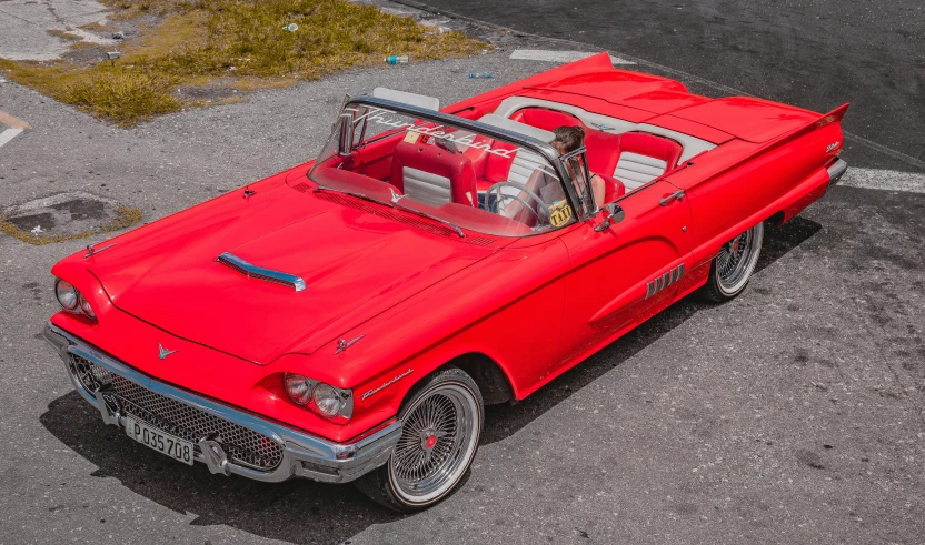 an overhead view of a classic red convertible car in parking space