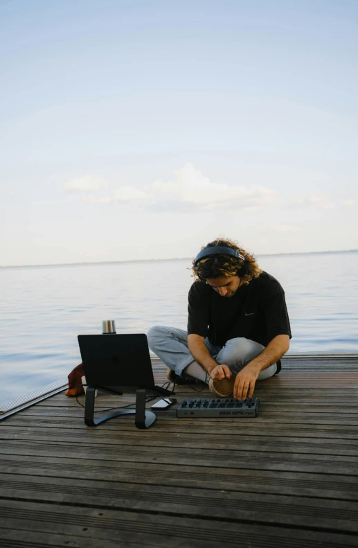 man with eye glasses sitting on deck on water