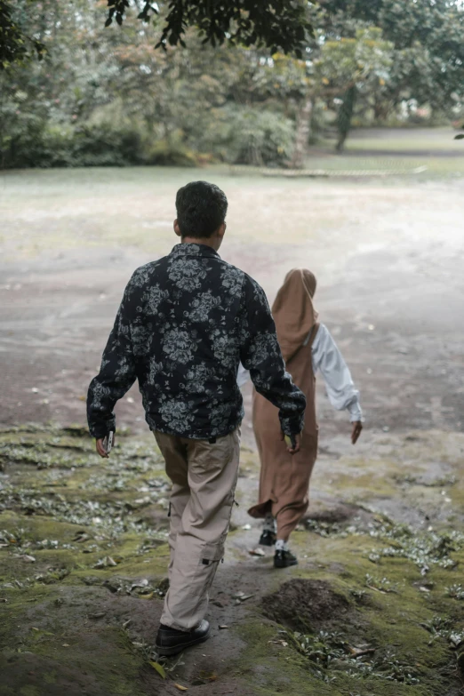 two people walk through the field near each other