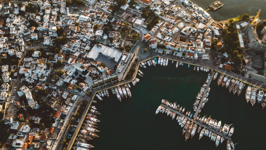 an aerial view of a city with several boats in the water