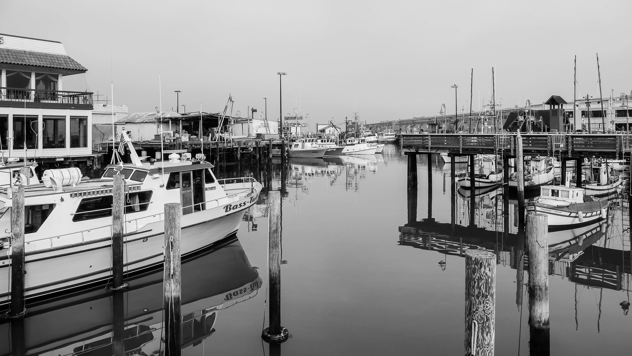 several boats moored near a pier in the harbor