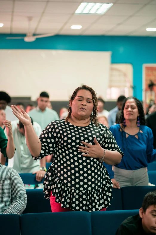 woman in black shirt clapping over a group of people