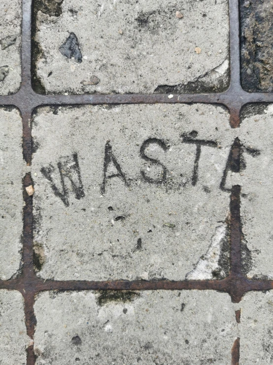 this brick pavement has a word that says west and a arrow on it