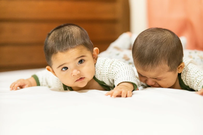 two young children play on the bed