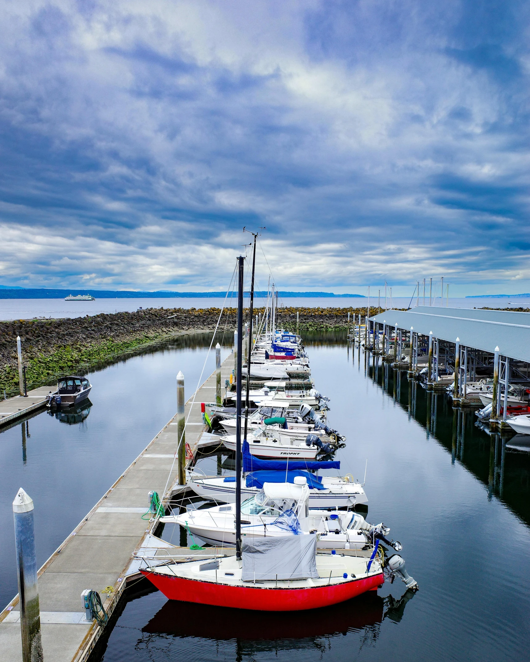 several boats parked on a pier near some docks