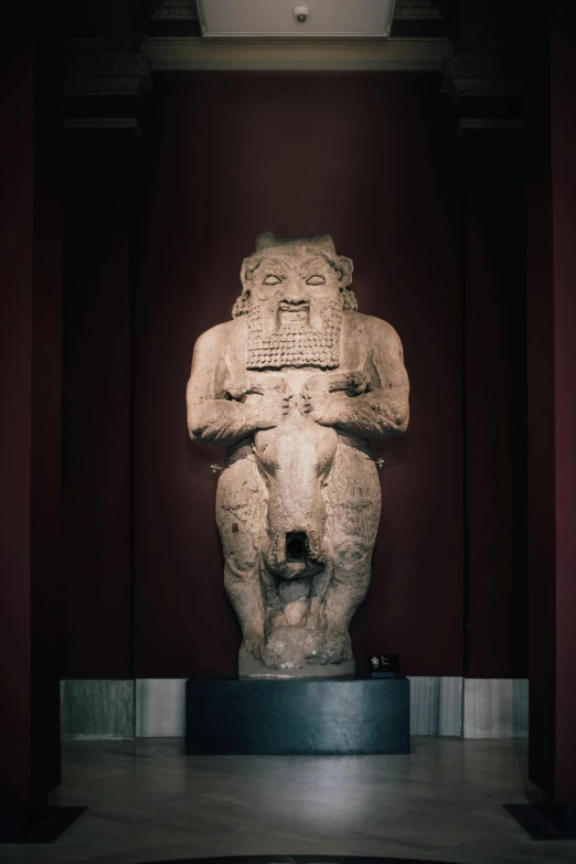 a stone sculpture in a red room, some are on display