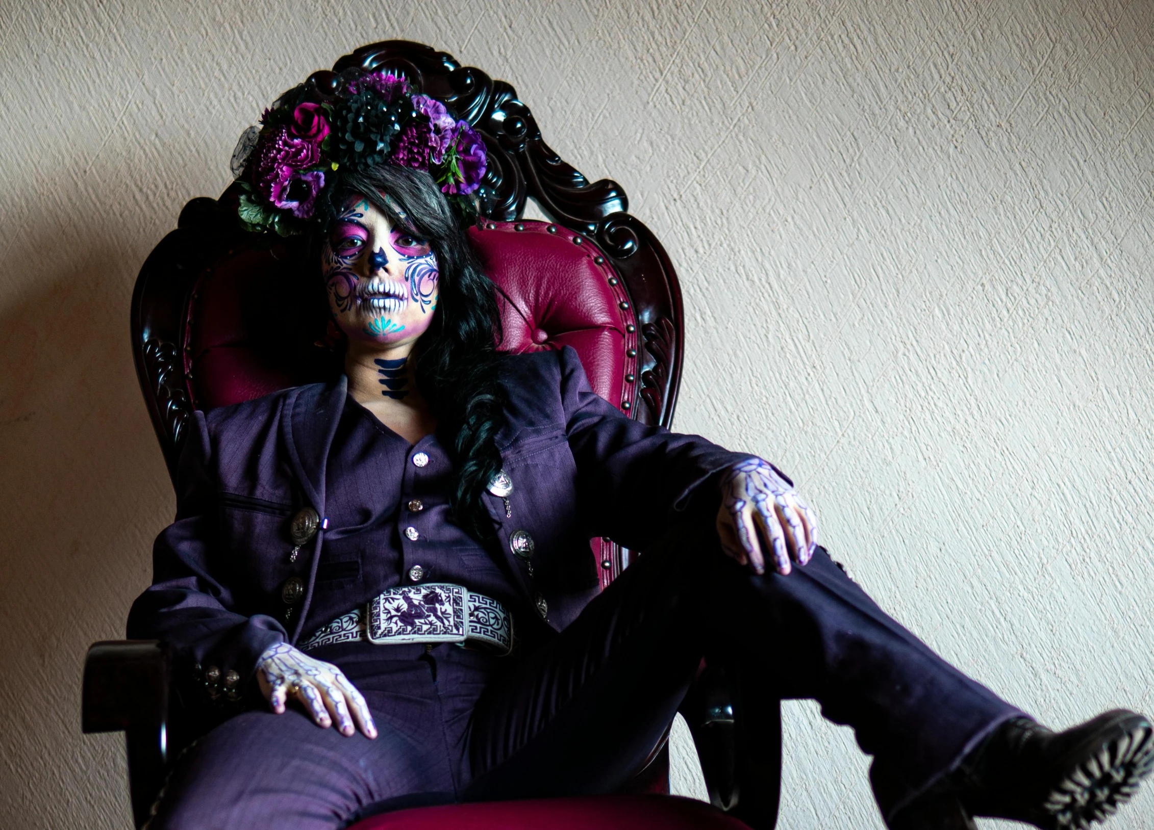 a person with a skeleton makeup sitting in a chair