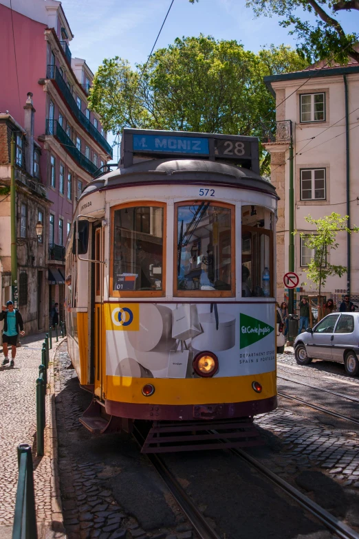 an old tram driving down the tracks in the city