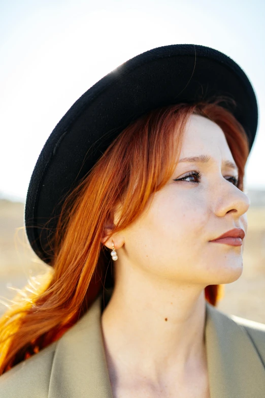 a girl with red hair wearing a hat