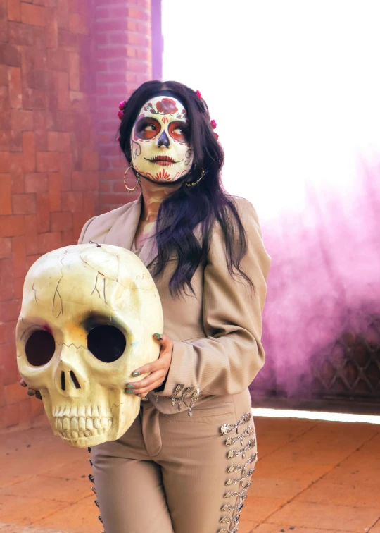 the young woman is wearing makeup as she holds a skull shaped object