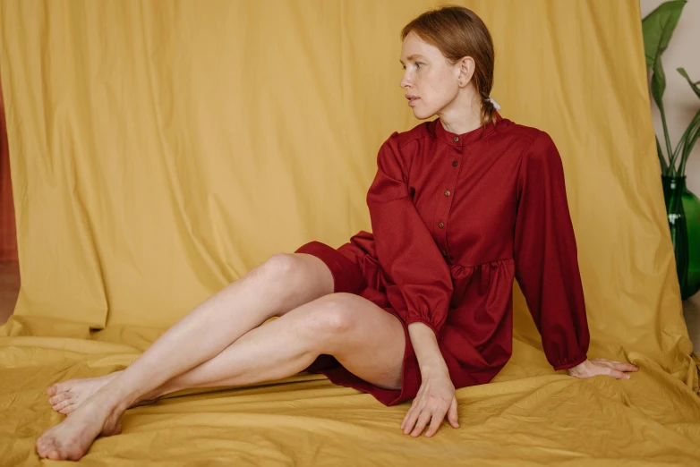 woman in red shirt sitting on orange cloth