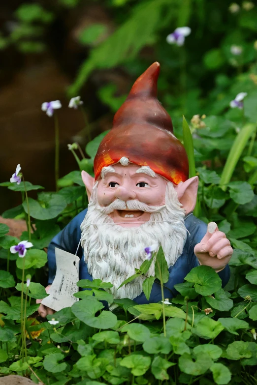 a gnome sitting on top of green plants