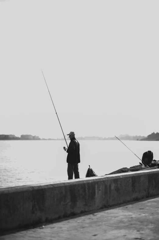 a black and white po of a man fishing on a lake