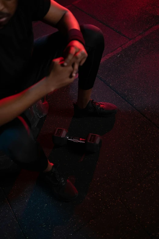 a man sits on top of a skateboard with his hands clasped up