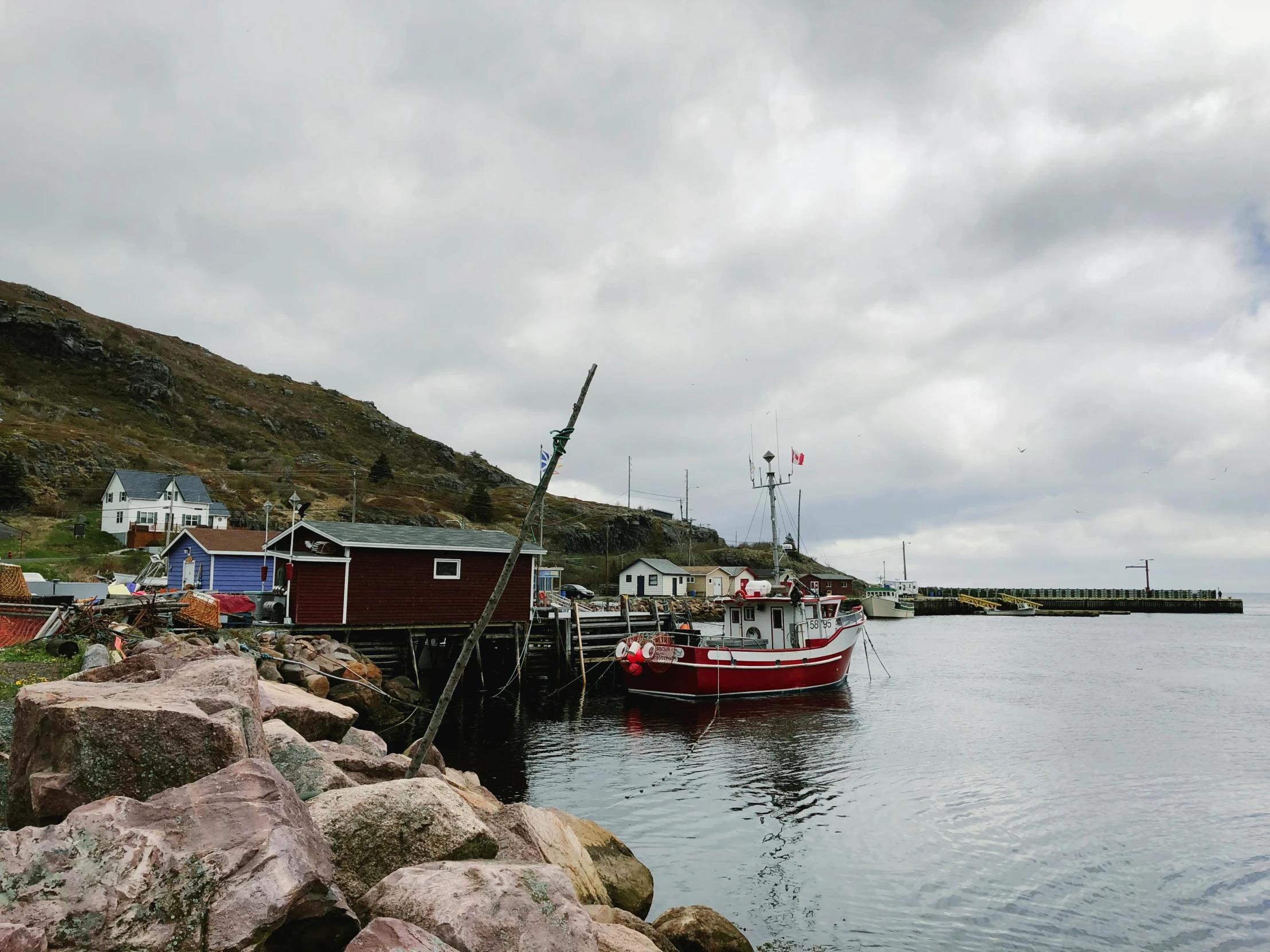 a boat parked next to some rocks near the water