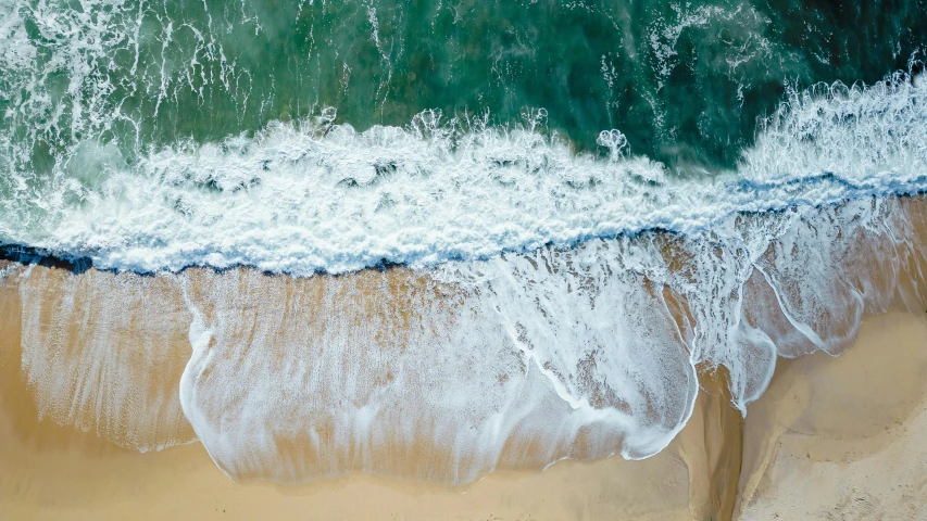 there are waves on the beach and blue ocean