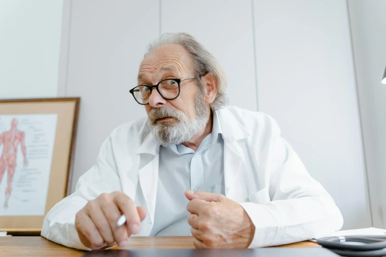 an old man sitting at a desk looking into a magnifying glass